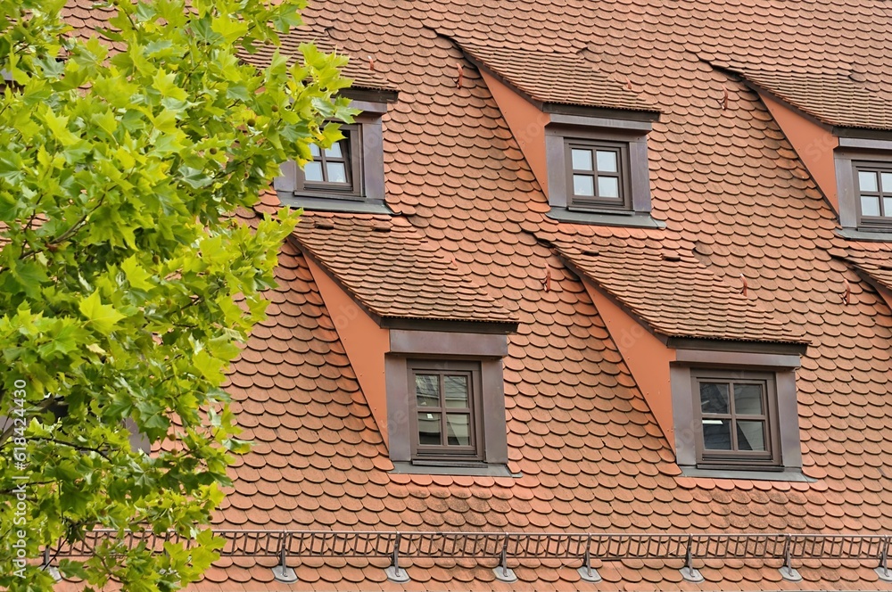 Exterior view of a traditional red-tiled roof house with ornate window frames