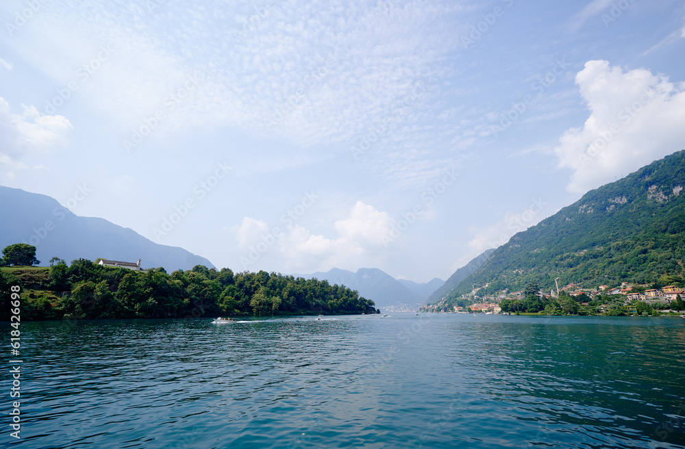 Beautiful scene of lake Como in Italy. A big blue lake surrounded by green hill.