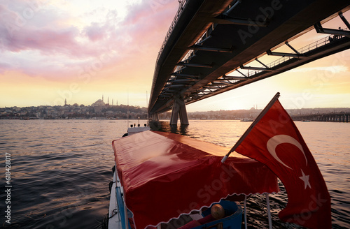 Travel by Tukey. Boat under Halic Metro Bridge in Istanbul. Modern cable bridge. Beautiful sunset view on Golden Horn. photo