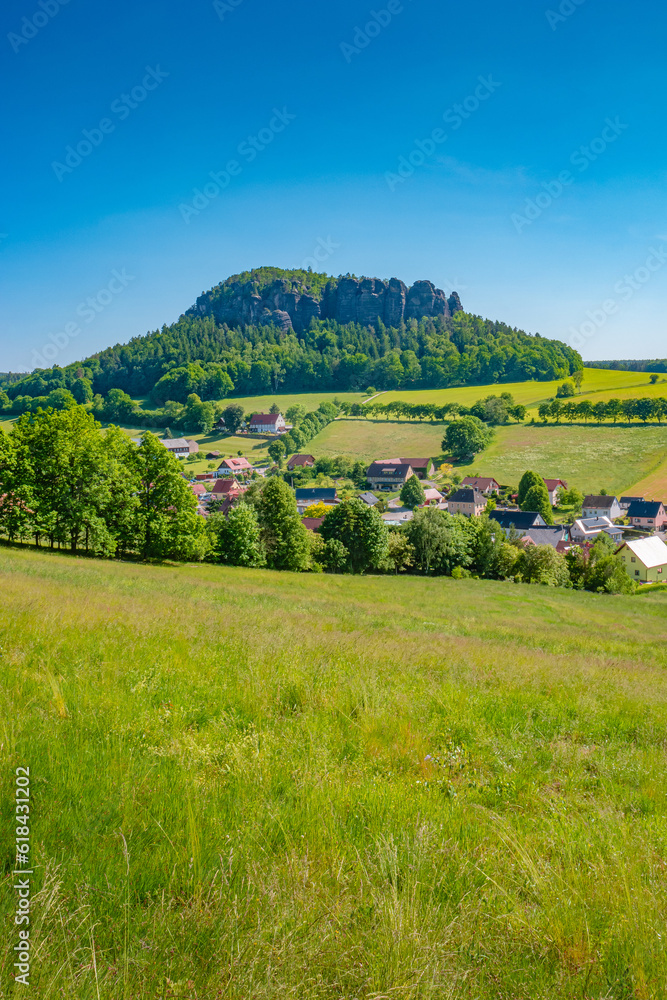 Obraz premium Königstein, Saxony, Germany. View the mount Pfaffenstein and its sandstone rockss in the national park Saxon Switzerland by Elbe river and green countryside fields and forests