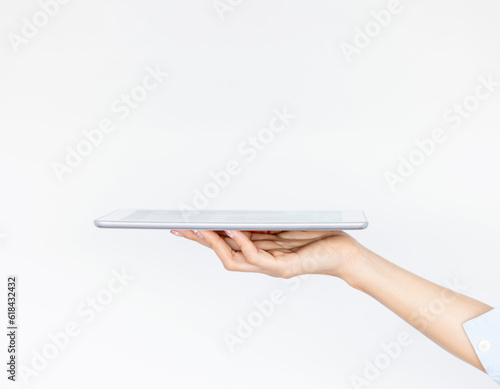 Close up,woman hand holding tablet computer isolated on white background.Elegant palm faced upwards with tablet computer.Woman holding computer horizontally.Tablet put on woman's hand.Space for text.