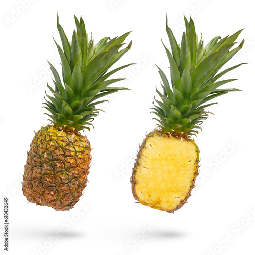Whole unpeeled pineapple on a white isolated background. Juicy pineapple with peel and long green leaves, in two parts, cut lengthwise isolated on white. High quality photo.