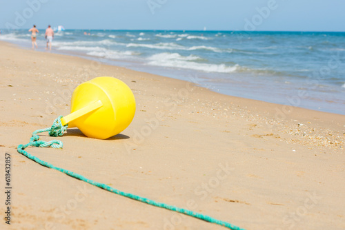 Buoy and rope dividing area on beach.