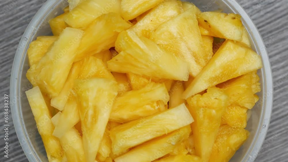 Pineapple fruit slices in transparent plastic container, concept for health and fitness Pineapple fruit slices in transparent plastic container, concept for health and fitness