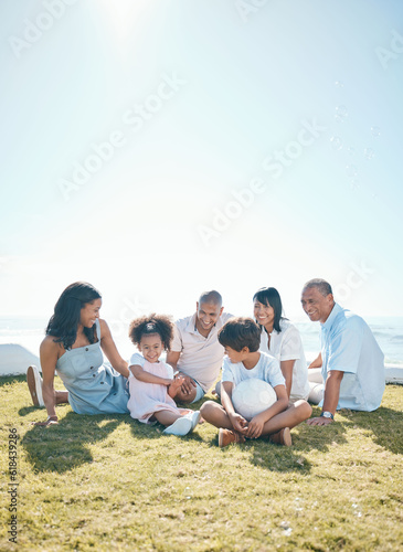 Parent, children and generations are relaxing on grass in summer for quality time on holiday in mockup space. Happiness, kid and big family in outdoor for bond at resort with ball at house or ocean.