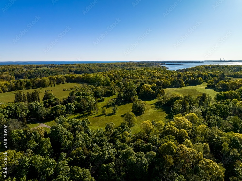 Aerial view, high over the green landscape on Long Island, New York with Oyster Bay in background