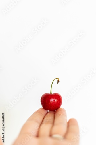 Vibrant single red cherry isolated on a white background © Brooklynn Hossler/Wirestock Creators