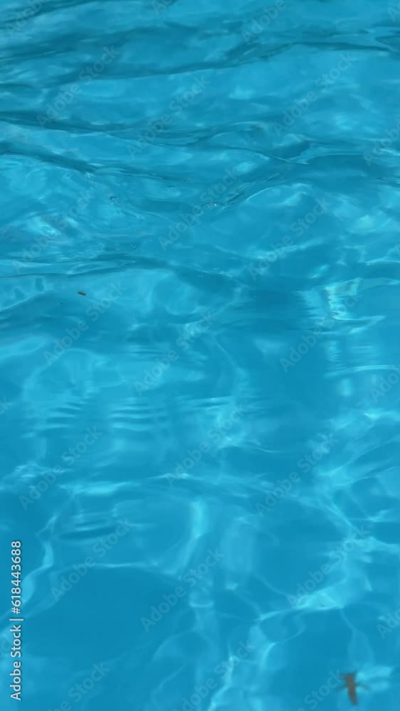 Meditational summer vibe of clear water in the blue swimming pool. Shimmering reflections of the sun create a cinematic view. Ripples on the surface. Spa resort or hotel lounge. Meditational summer vibe of clear water in the blue swimming pool. Shimmering reflections of the sun create a cinematic view. Ripples on the surface. Spa resort or hotel lounge.