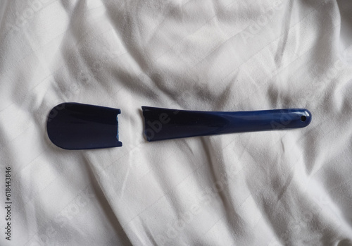 broken shoehorn on bed sheet photo