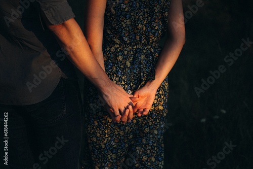 Happy young couple posing in a sun-drenched meadow at sunset. photo