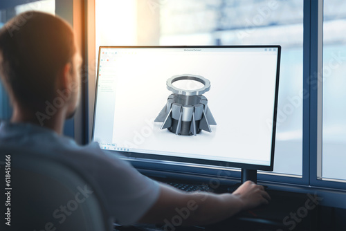 Obraz na plátně An engineer designs machine components on a computer using CAD software at a company manufacturing machines for the industry