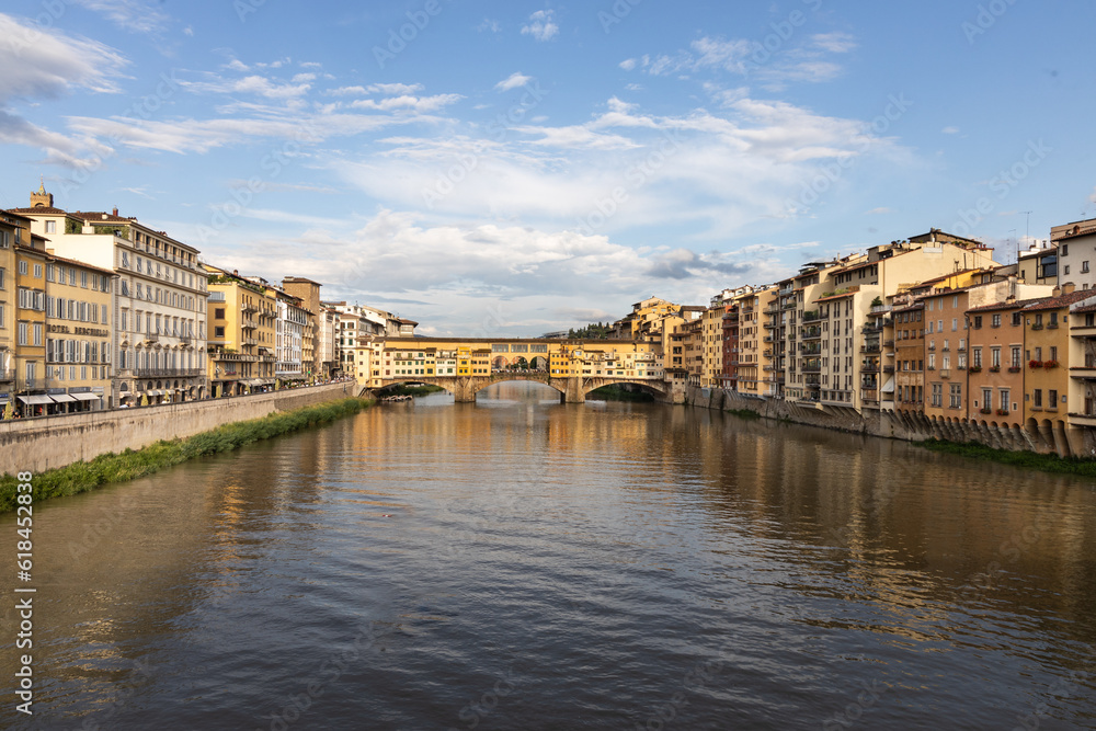 The Arno river in Florence Italy with Ponte Vecchio, the historic bridge from a distance.