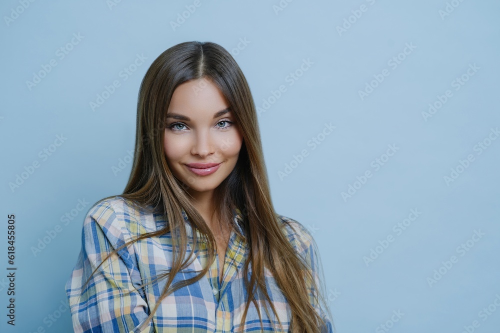 Good-looking student poses with charming smile, checkered shirt, optimistic for university photo Good-looking student poses with charming smile, checkered shirt, optimistic for university photo