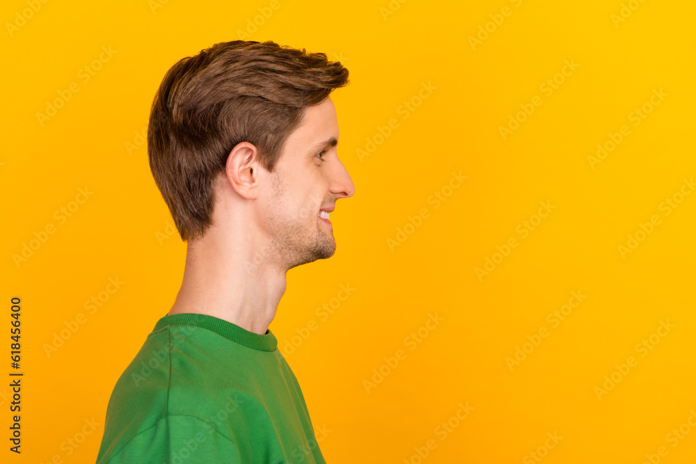 Profile portrait of handsome bearded adult european man with trendy haircut, standing over yellow background Profile portrait of handsome bearded adult european man with trendy haircut, standing over yellow background