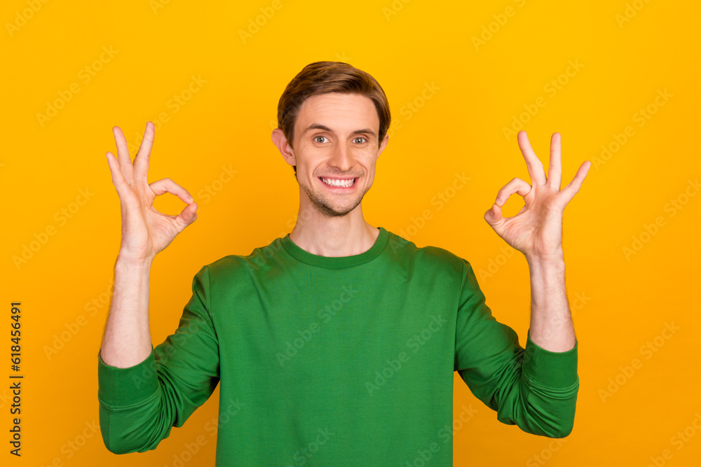Prtrait young smiling happy man in casual clothes shows OK sign with his hand isolated on yellow background with space for text concept sale Prtrait young smiling happy man in casual clothes shows OK sign with his hand isolated on yellow background with space for text concept sale