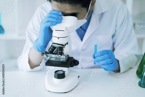 Science and medicine, scientist analyzing and dropping a sample into a glassware, experiments containing chemical liquid in laboratory on glassware, innovative and technology.