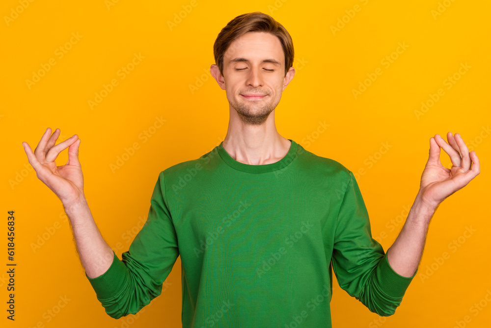 Portrait of attractive dreamy calm brunet guy meditating isolated over bright color background Portrait of attractive dreamy calm brunet guy meditating isolated over bright color background