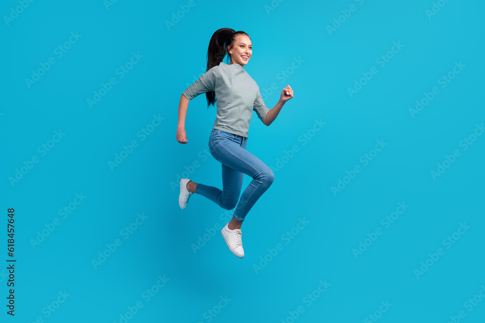 Photo of pretty charming woman dressed outfit jumping high running fast empty space isolated blue color background