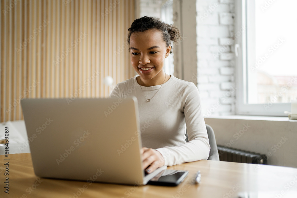 Female startup assistant on an online project. Uses a laptop to print a message. The employee on the monthly report and analytics working day in the office. Female startup assistant on an online project. Uses a laptop to print a message. The employee on the monthly report and analytics working day in the office.