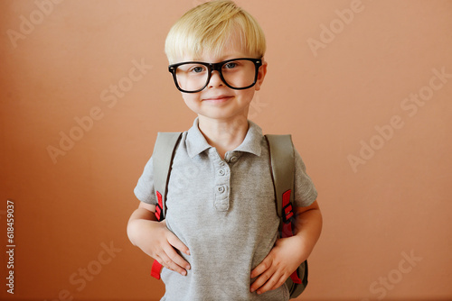 a blond schoolboy in glasses and with a backpack