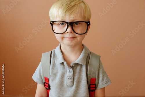 a blond schoolboy in glasses and with a backpack