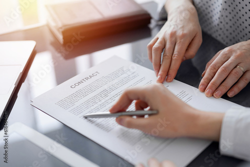 Business people discussing contract signing deal while sitting at the glass table in office, closeup. Partners or lawyers working together at meeting. Teamwork, partnership, success concept