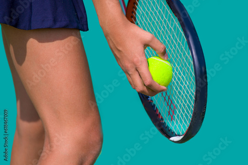Close-up of a tennis player's hand holding a tennis ball and racket