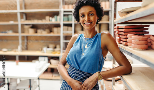 Fotografie Successful female ceramist and entrepreneur standing in her shop