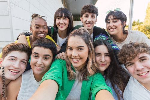 Multi-ethnic group of nine teenagers taking a selfie sitting on steps