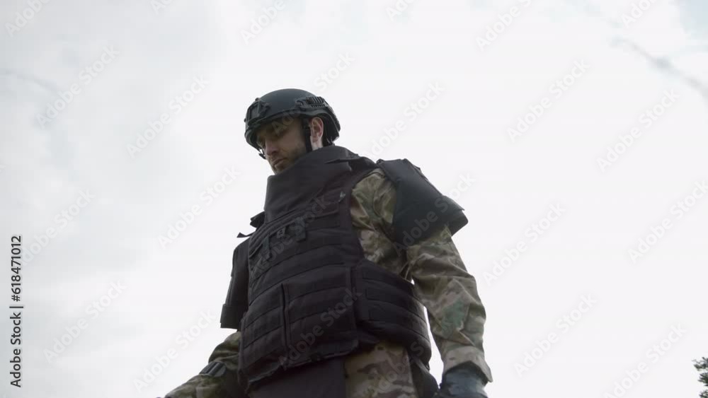 Man trying to detect mine in demining process in grass near the forest. Slow motion