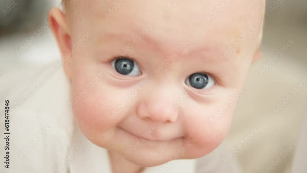 Happy baby. Cute little newborn girl with smiling face crawling on bed in bedroom. Infant baby resting playing lying down on blanket at home. Motherhood happy child childcare concept Happy baby. Cute little newborn girl with smiling face crawling on bed in bedroom. Infant baby resting playing lying down on blanket at home. Motherhood happy child childcare concept