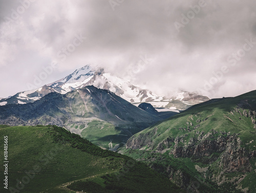 The snowy peak in clouds in summer