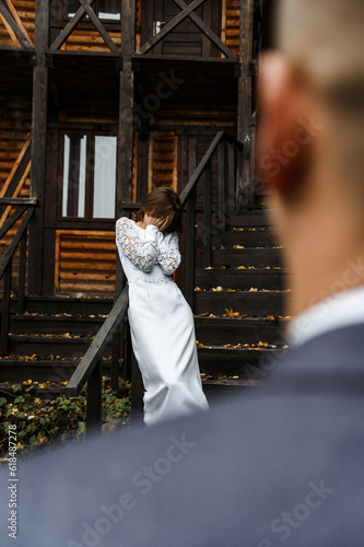 bride on a wooden staircase. wedding day in autumn.