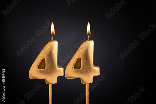 Golden candle 44 with flame - Birthday card on dark luxury background
