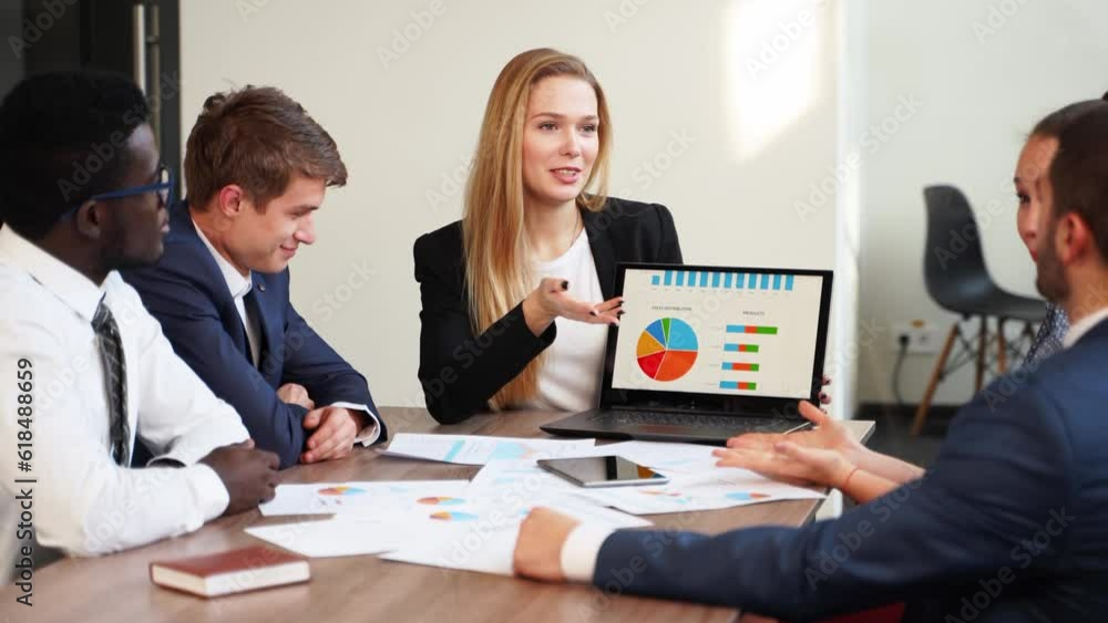 Business woman makes a presentation with charts, diagrams for multiethnic partners. Startup team discuss project plan. Diverse multinational people have meeting in office listening to supervisor. Business woman makes a presentation with charts, diagrams for multiethnic partners. Startup team discuss project plan. Diverse multinational people have meeting in office listening to supervisor.