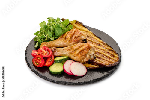 Fried chicken drumsticks served with grilled eggplants, isolated on white background.