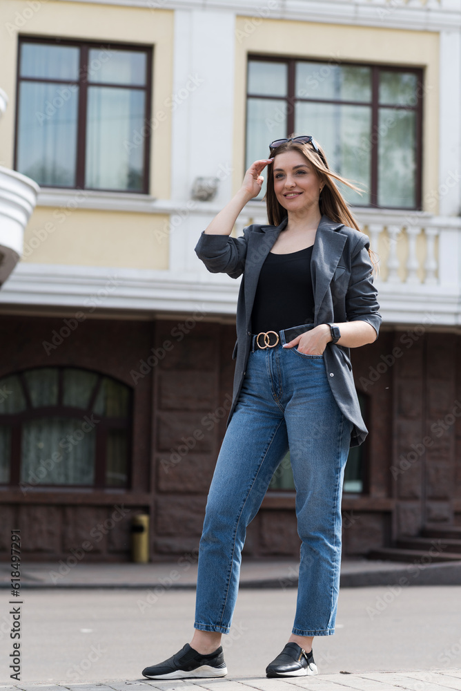 Portrait of a happy smiling woman in casual clothes while walking around the city.