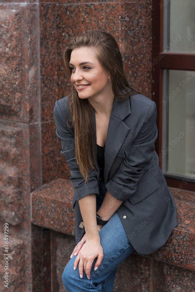 Portrait of a happy smiling woman in casual clothes sitting by the window.