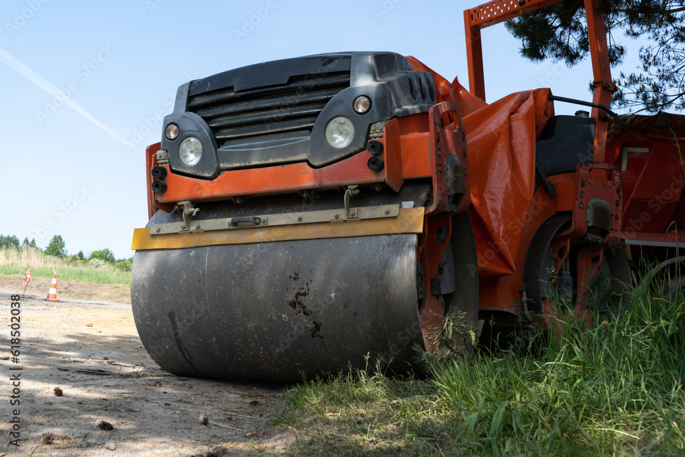 Tandem roller machine at construction site of a new road. Soil compactor with roller drums for compacting the asphalt layer.