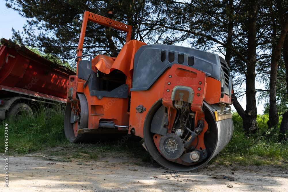 Tandem roller machine at construction site of a new road. Soil compactor with roller drums for compacting the asphalt layer.