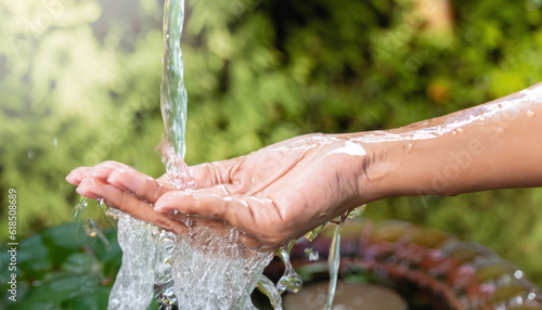 Close-up Water Flow to Woman's Hand for Nature Concept on Garden Background
