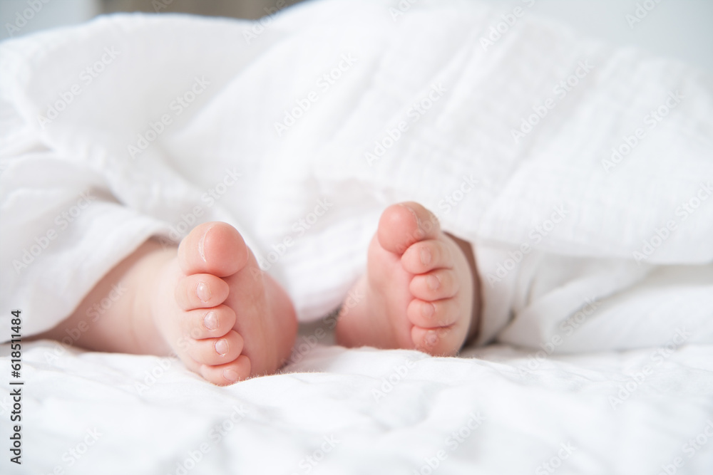 baby bare feet on a white bed with a white blanket baby bare feet on a white bed with a white blanket