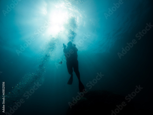 Diver silhouette and bubbles in deep water.