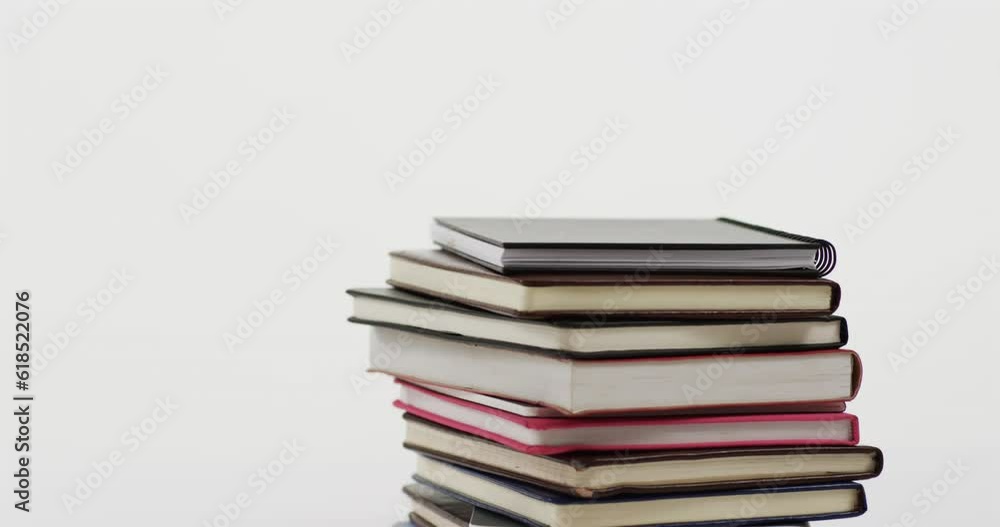 Close up of stack of books on grey background, in slow motion Close up of stack of books on grey background, in slow motion