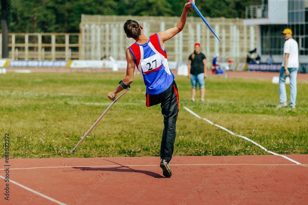 Obraz premium male athlete without leg with crutch javelin throw at athletics championships, summer sports games