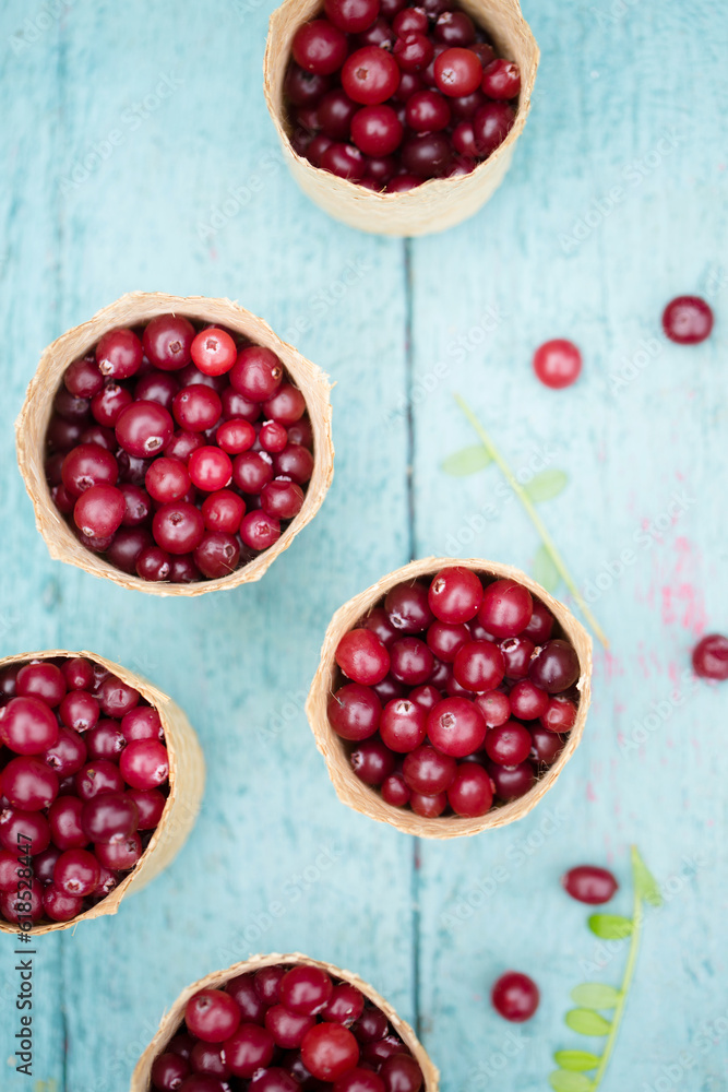 berry cranberries in small wicker baskets on a blue background berry cranberries in small wicker baskets on a blue background