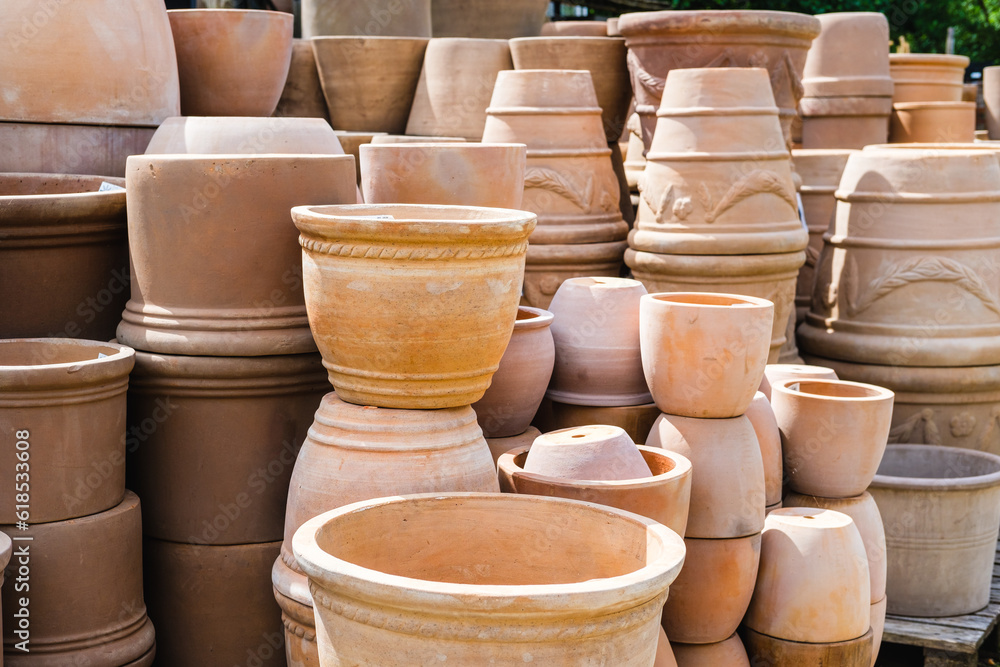 A variety of empty stacked ceramic terracotta flower pots in different sizes and shapes at the garden center A variety of empty stacked ceramic terracotta flower pots in different sizes and shapes at the garden center