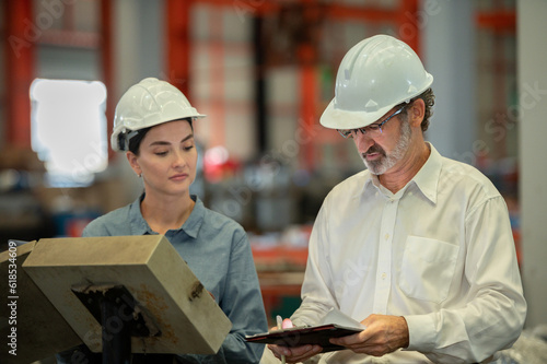 woman engineer assistant secretary in helmet inspection check control heavy machine construction installation in industrial factory with boss manager. Boss and partnership check maintenance factory