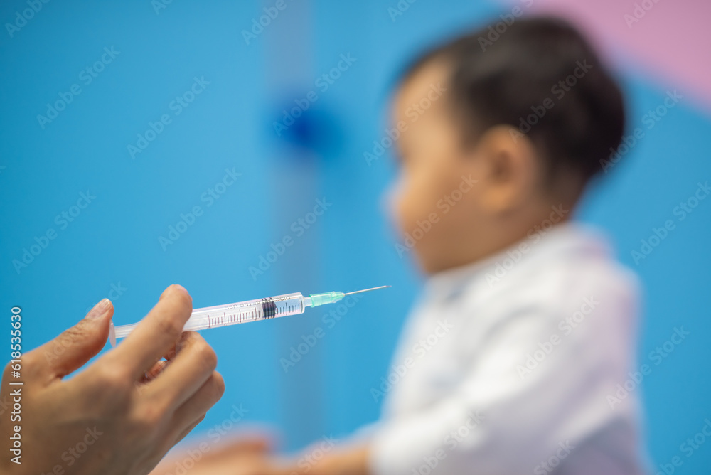 pediatrician Hand hold vaccine liquid injection in syringe for injecting child baby infant. small syringe needle for infant prevention flu by vaccination immunity in Pediatrics hospital clinic. pediatrician Hand hold vaccine liquid injection in syringe for injecting child baby infant. small syringe needle for infant prevention flu by vaccination immunity in Pediatrics hospital clinic.