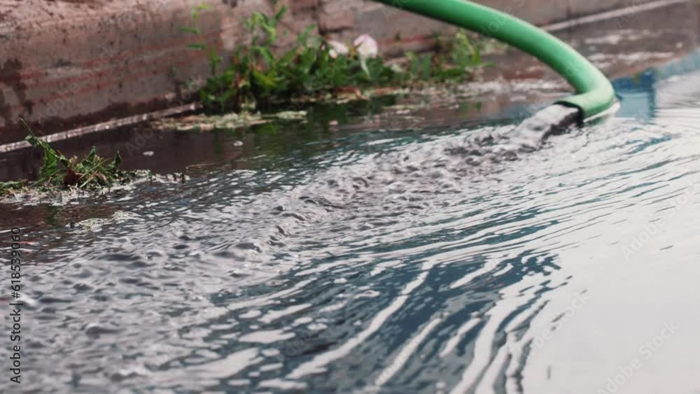 Video. Water flows from rubber hose to ground. Dirty water pumping. Puddle from bottom of survey. Video. Water flows from rubber hose to ground. Dirty water pumping. Puddle from bottom of survey.
